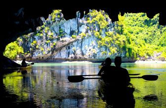The silhouettes of people kayaking inside of a cave in Lan Ha Bay, Cat Ba National Park, close to Halong Bay, Vietnam